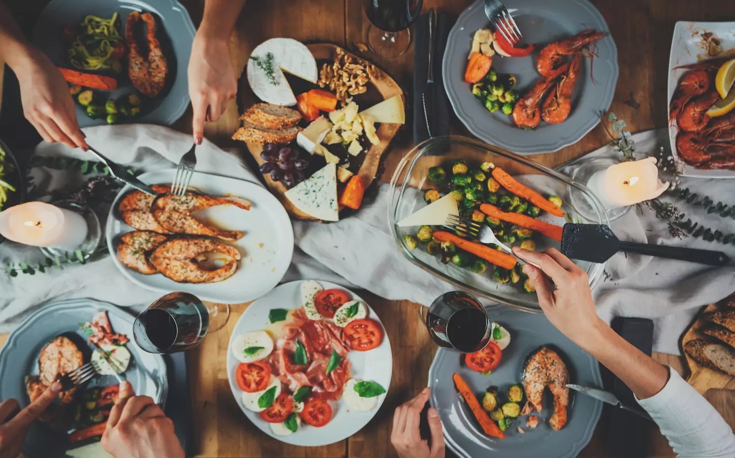 a table filled with Thanksgiving food and surrounded by family and friends