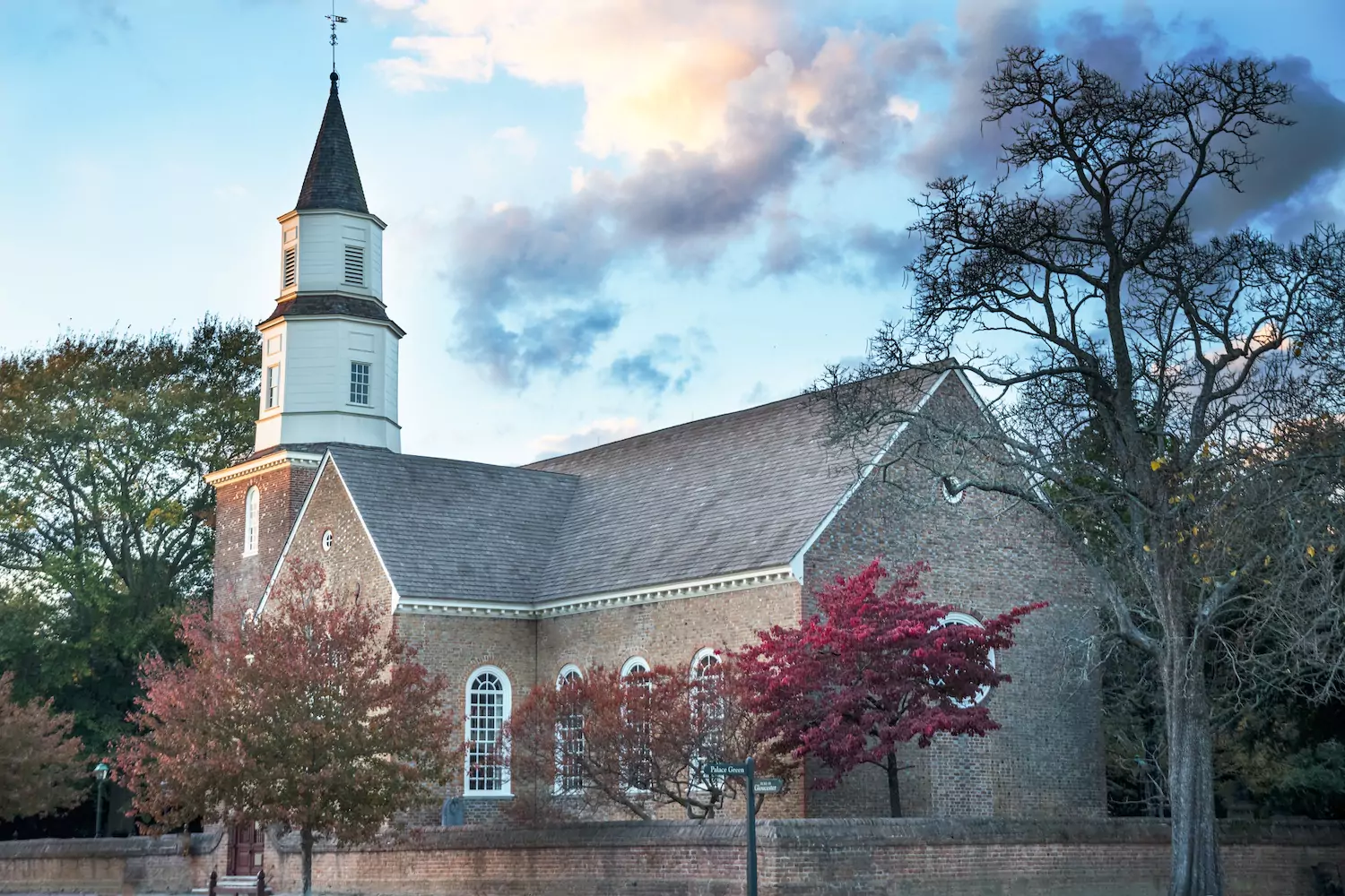 A Bible preaching church sits among trees.