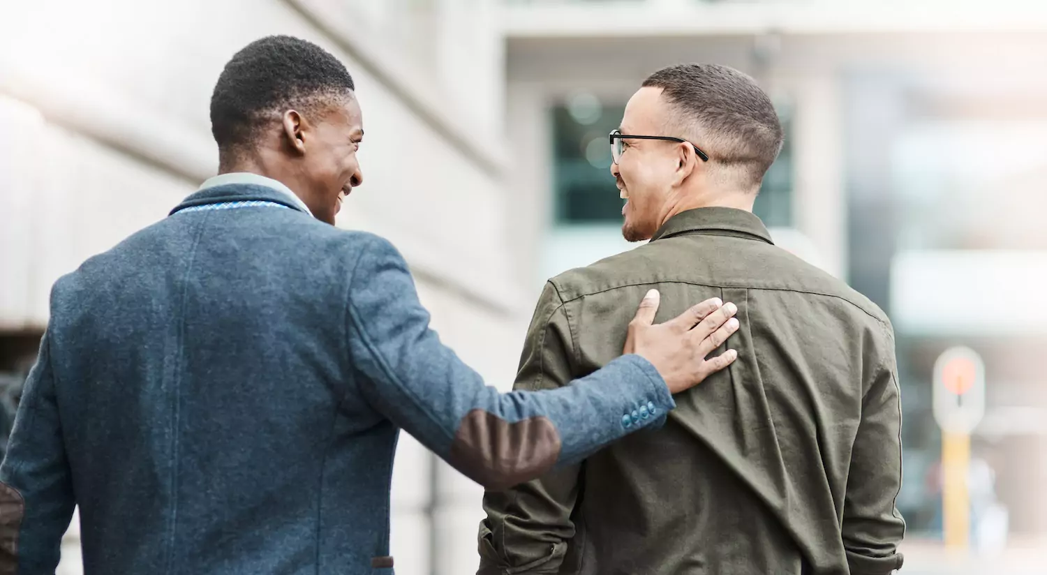 An associate pastor encourages the lead pastor, putting his hand on his shoulder as they walk.